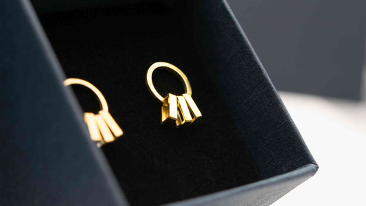 Gold sway earrings in a jewellery box