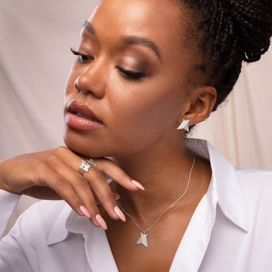 A person wearing minimal sterling silver earrings
