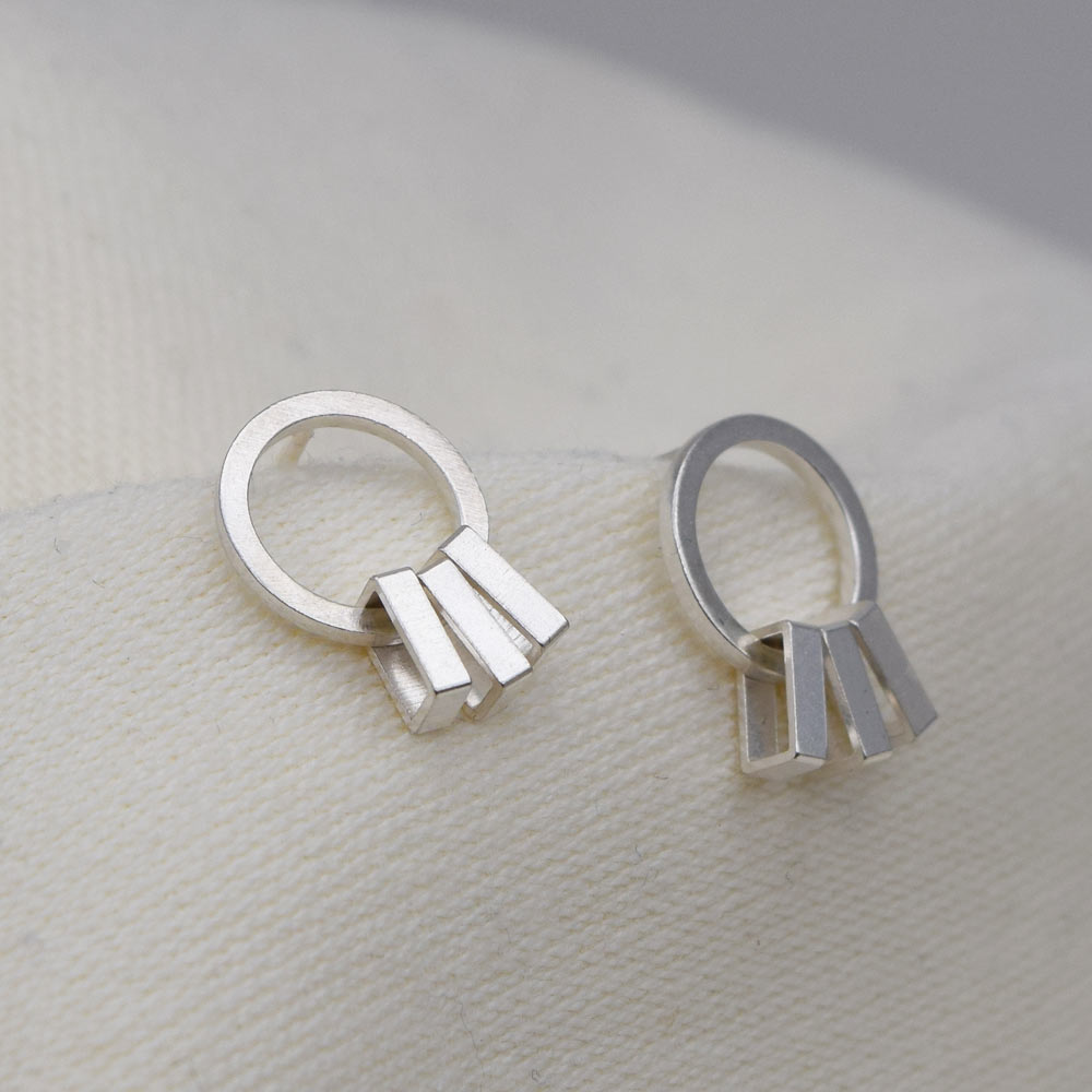 A pair of silver sway earrings with a geometric rectangular form, displayed against a neutral background.