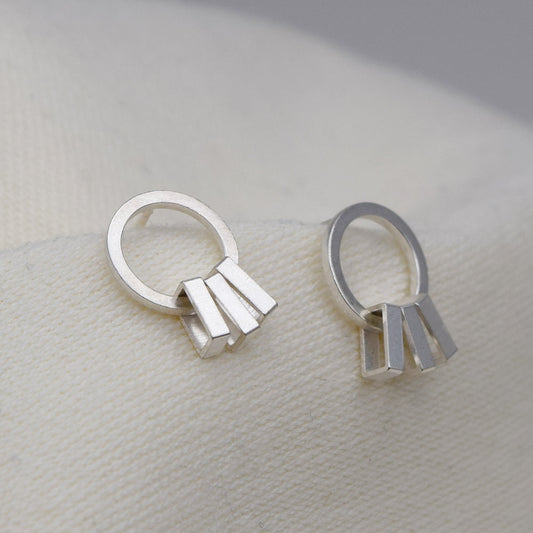 A pair of silver sway earrings with a geometric rectangular form, displayed against a neutral background.