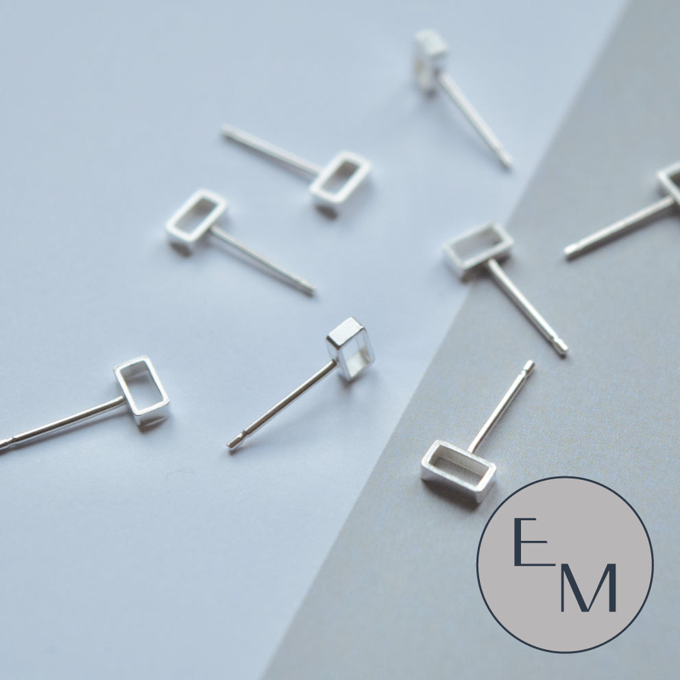 A pair of silver mini brickwork stud earrings on a white background.
