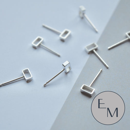 A pair of silver mini brickwork stud earrings on a white background.