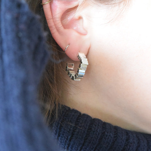 Geometric sterling silver hoops being worn
