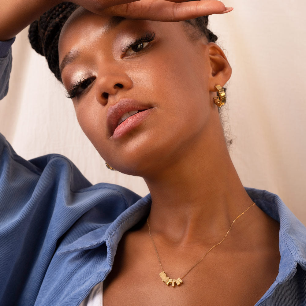 Gold plated hoop earrings being worn with a gold necklace